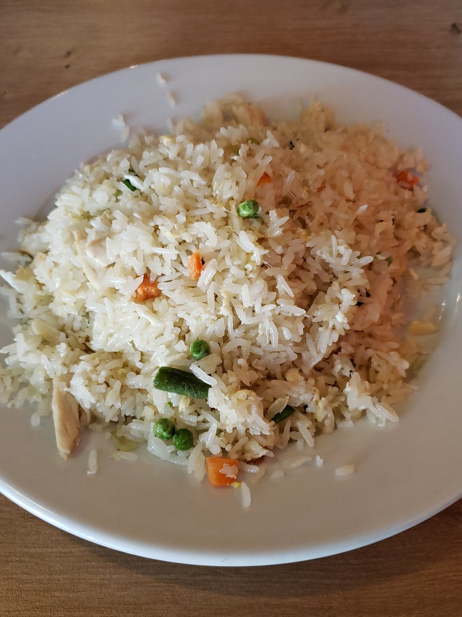 Tiquete de precio de papel blanco sujeto con un clip negro sobre una foto cenital de comida cocida para perro con pollo, arroz y zanahoria; el tiquete dice Pollo con arroz en mayúsculas azules condensadas, el precio $ 48.000 y un código de barras negro, encuadre vertical